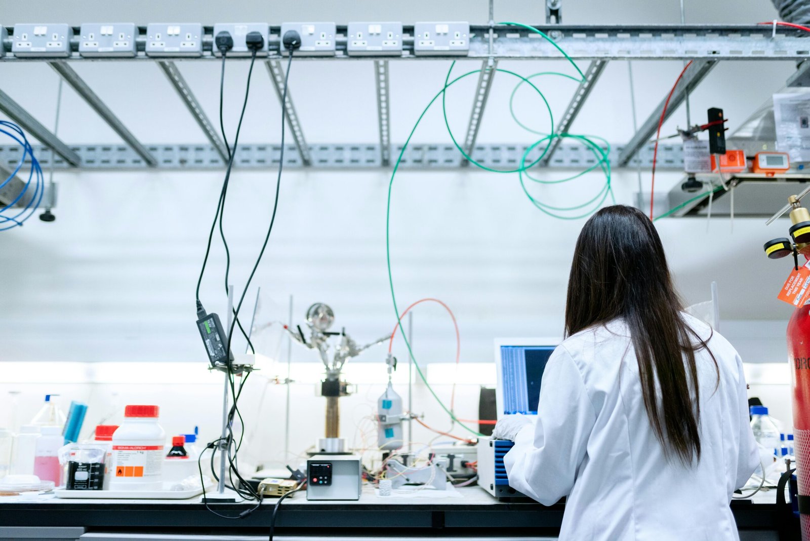 A female scientist conducting research in a contemporary laboratory full of equipment.